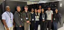 Group of colleagues posing together in a data center.