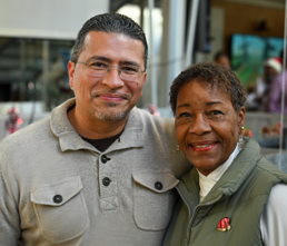 Two people smiling and posing together indoors.